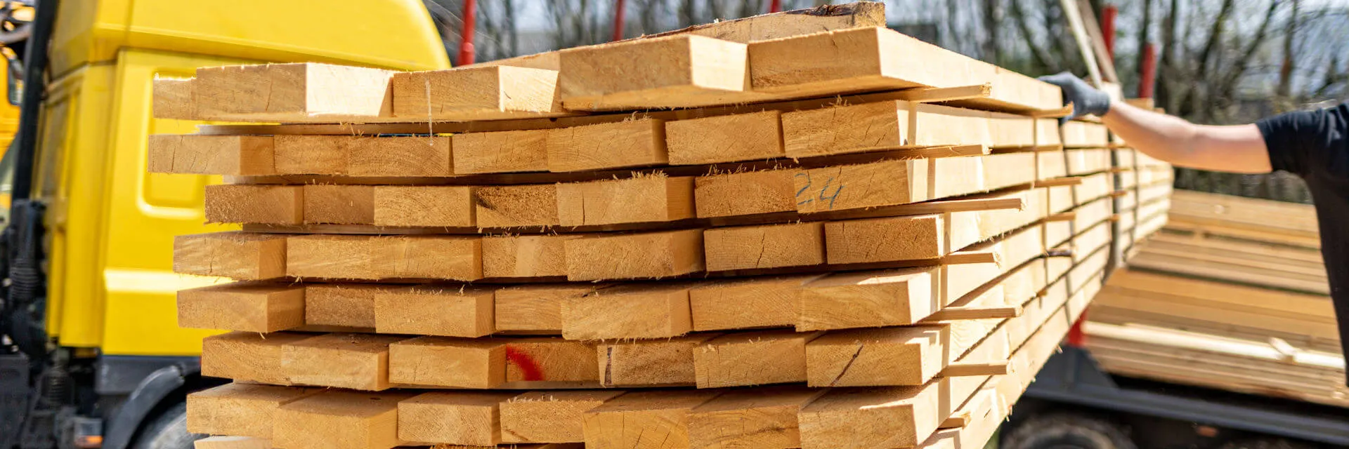 Lumber being unloaded by a Kidd's delivery truck